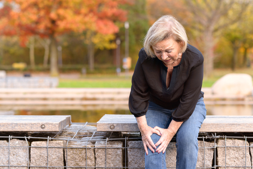 injured adult woman clutching knee