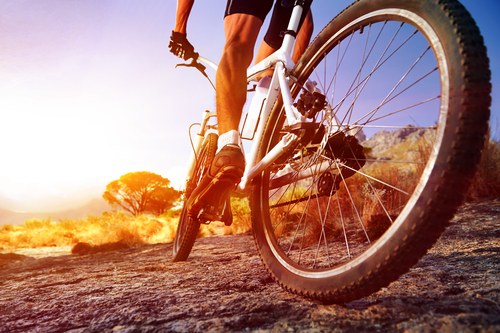 person on bicycle on dirt road