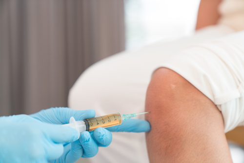 doctor injecting platelet rich plasma into knee joint