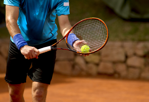 tennis player preparing to serve the ball