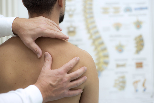 doctor checking patient's shoulder